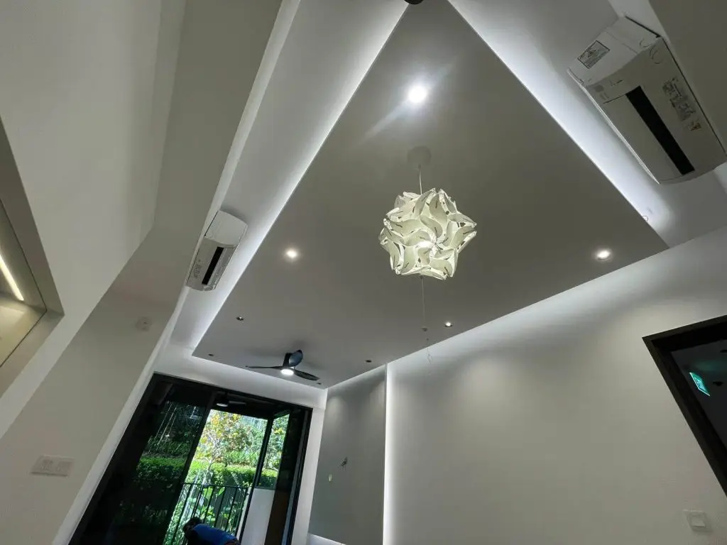 A modern living room at Parc Greenwich EC, Singapore, featuring an island covelight false ceiling with a cloud pendant light and 8 anti-glare spotlights, creating a layered lighting design.