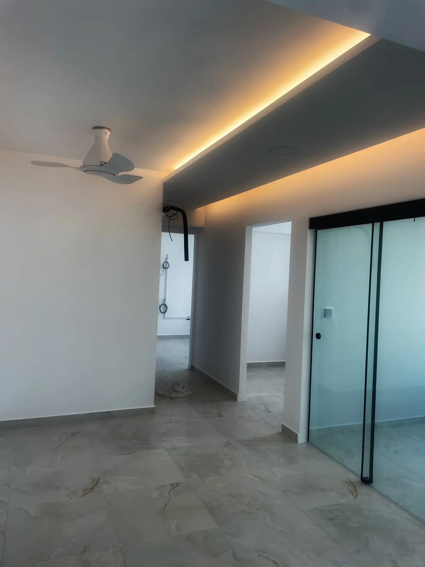 Home 4 A bedroom walkway in a Singapore apartment featuring a false ceiling with covelighting to provide a soft, ambient glow that defines the path