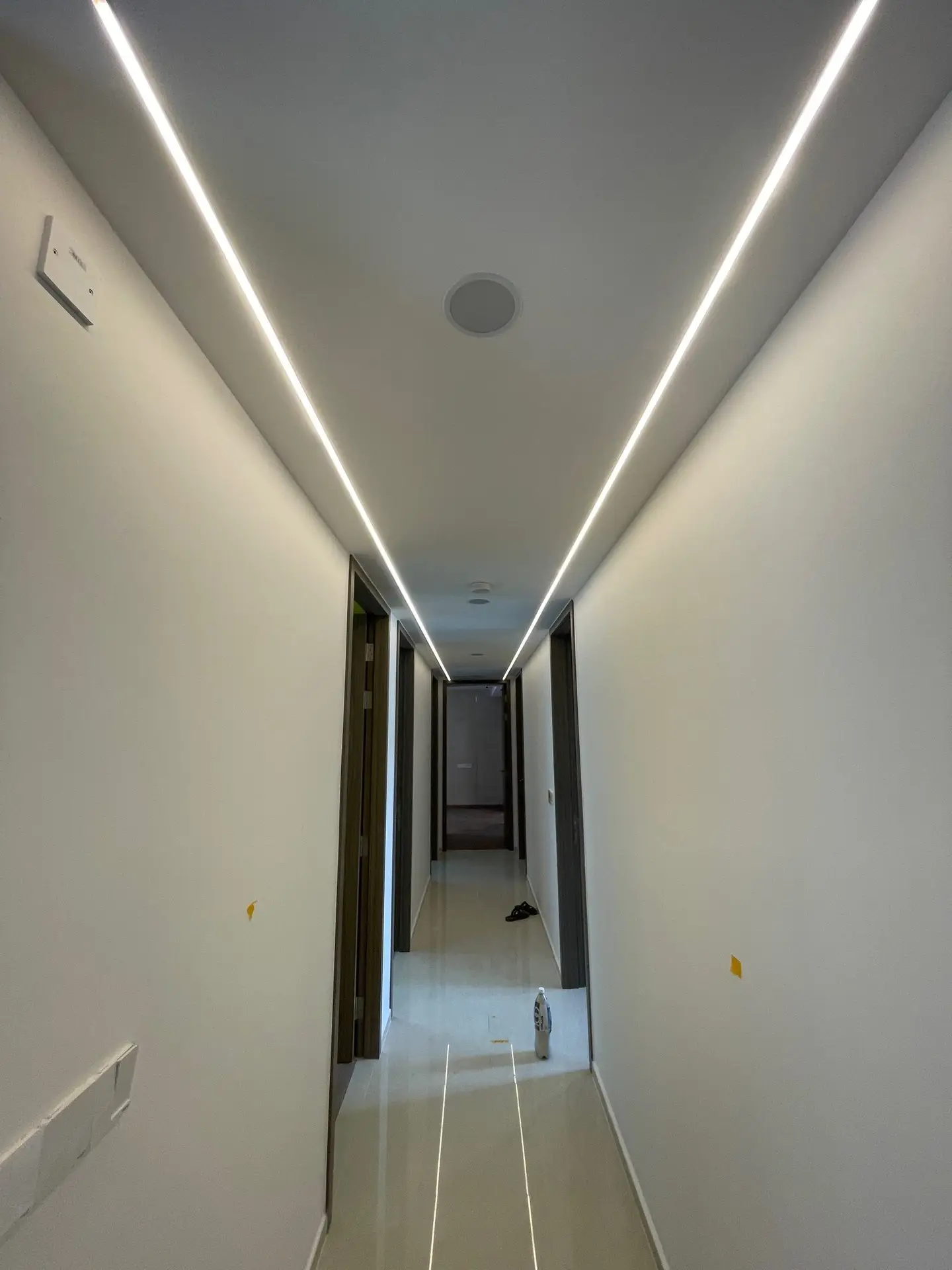 Home 5 A modern hallway at Copen Grand EC featuring a false ceiling with seamlessly integrated LED strip lights, creating a soft, continuous glow.