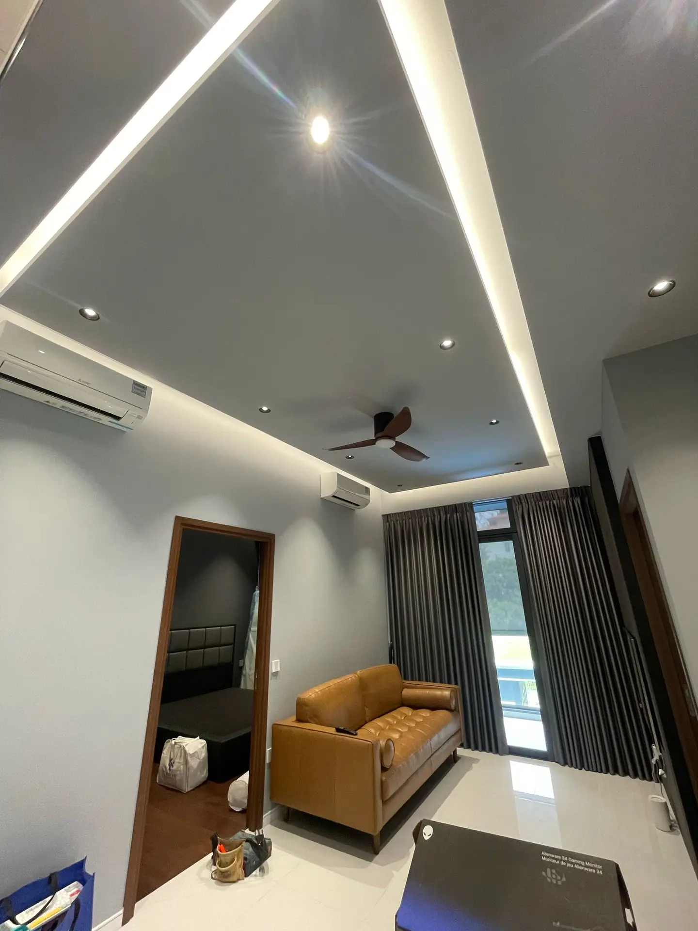 Home 3 A modern living room at Phoenix Residences featuring a rectangular island false ceiling with soft, indirect cove lighting, creating a stylish floating effect.